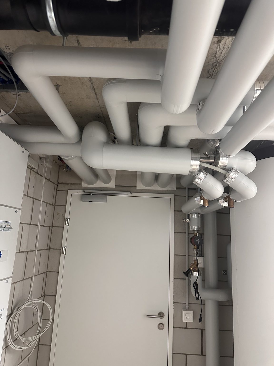 Sauber isolierte Heizungs- und Sanitärleitungen in einem Technikraum